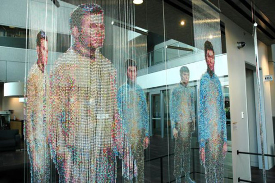 Installation view at Microsoft: Spock, Kirk, and McCoy Beaming-In (in-between), installed in front of an 8' x 12' mirror. Each figure constructed from 25,000+ colored faceted beads and silver bicone beads, monofilament, silver painted wooden dowels